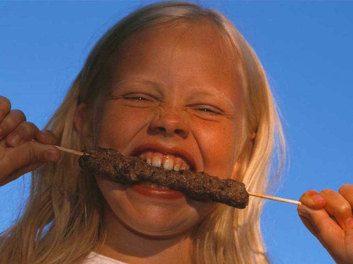 Flicka äter på spett - © Staffan Widstrand Flicka äter på spett